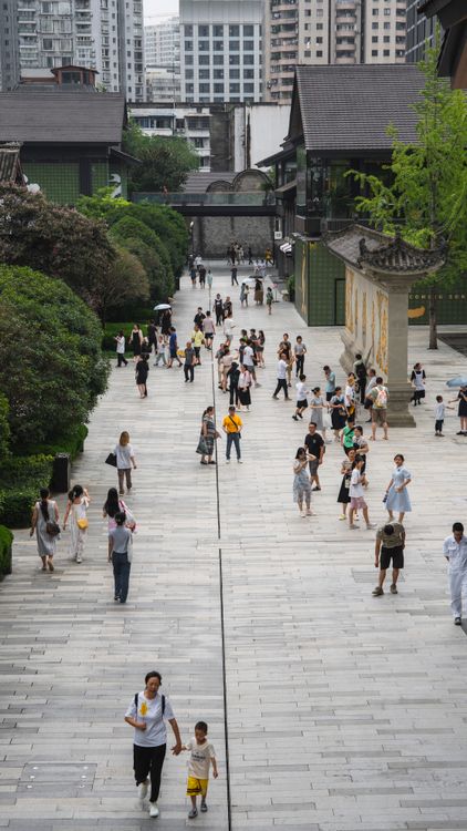 成都街区实拍，人们走在传统屋顶与现代楼宇之间